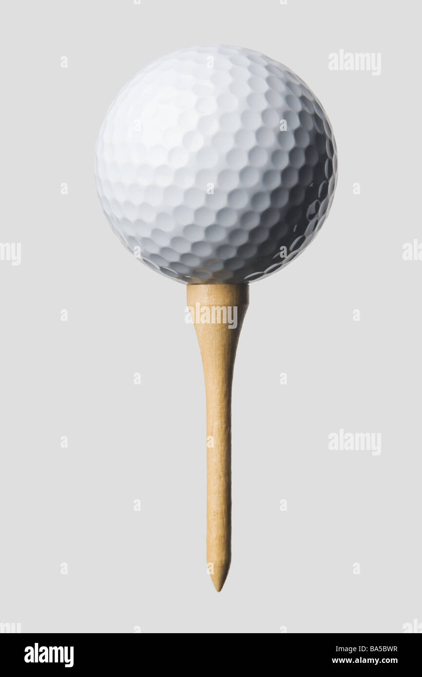 Nahaufnahme der weiße Golfball auf hölzernen Tee isoliert gegen grauen Hintergrund, Schatten von obere vordere linke Leuchte Stockfoto