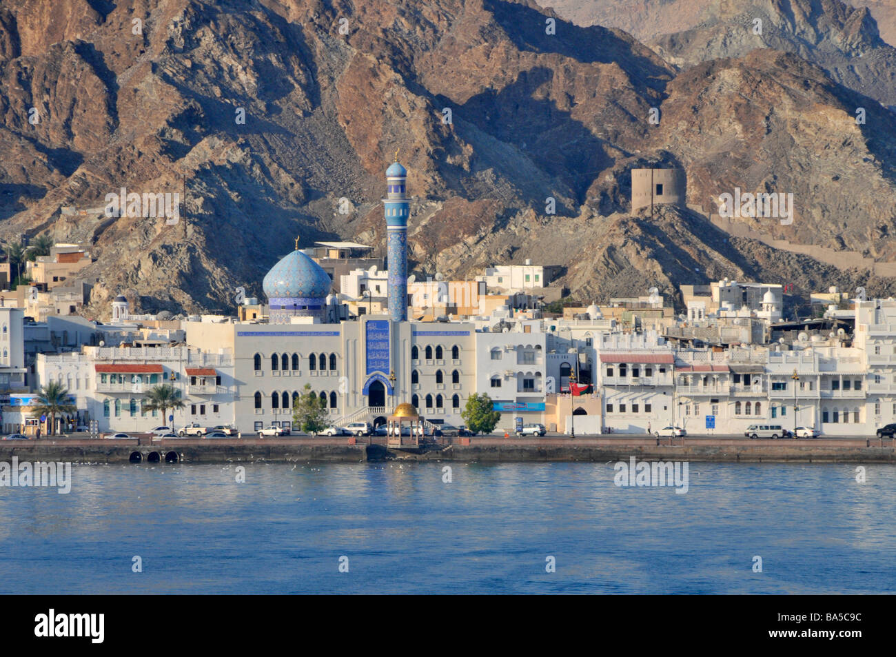 Küstenstraße am Golf von Oman und schmaler Entwicklungsstreifen im Hintergrund eines Teils der Hajar-Gebirgskette bei Muttrah in Muscat Oman Stockfoto