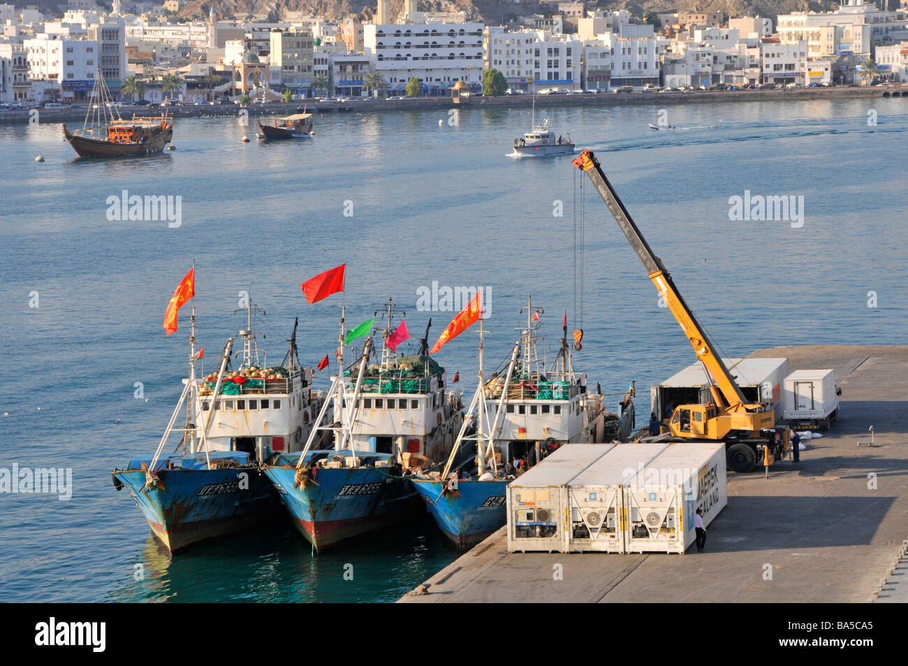 Waterfront und drei Fischerboote vertäut am Port Sultan Qaboos in Muttrah Dinkel auch als Mutrah Teil von Muscat Oman Stockfoto