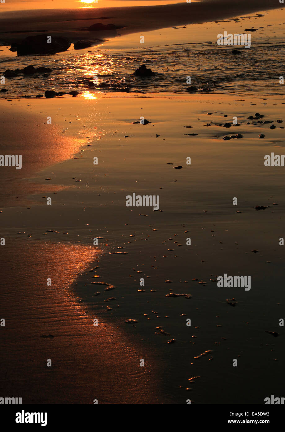 Die Glut der Sonnenuntergang auf dem Sand am Strand spiegelt in Sheringham in Norfolk England England Stockfoto