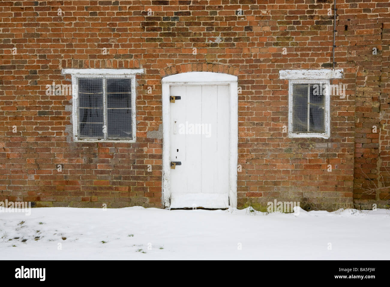 Tür und Fenster aus einem verlassenen Backstein gebaut Hütte im Schnee Stockfoto