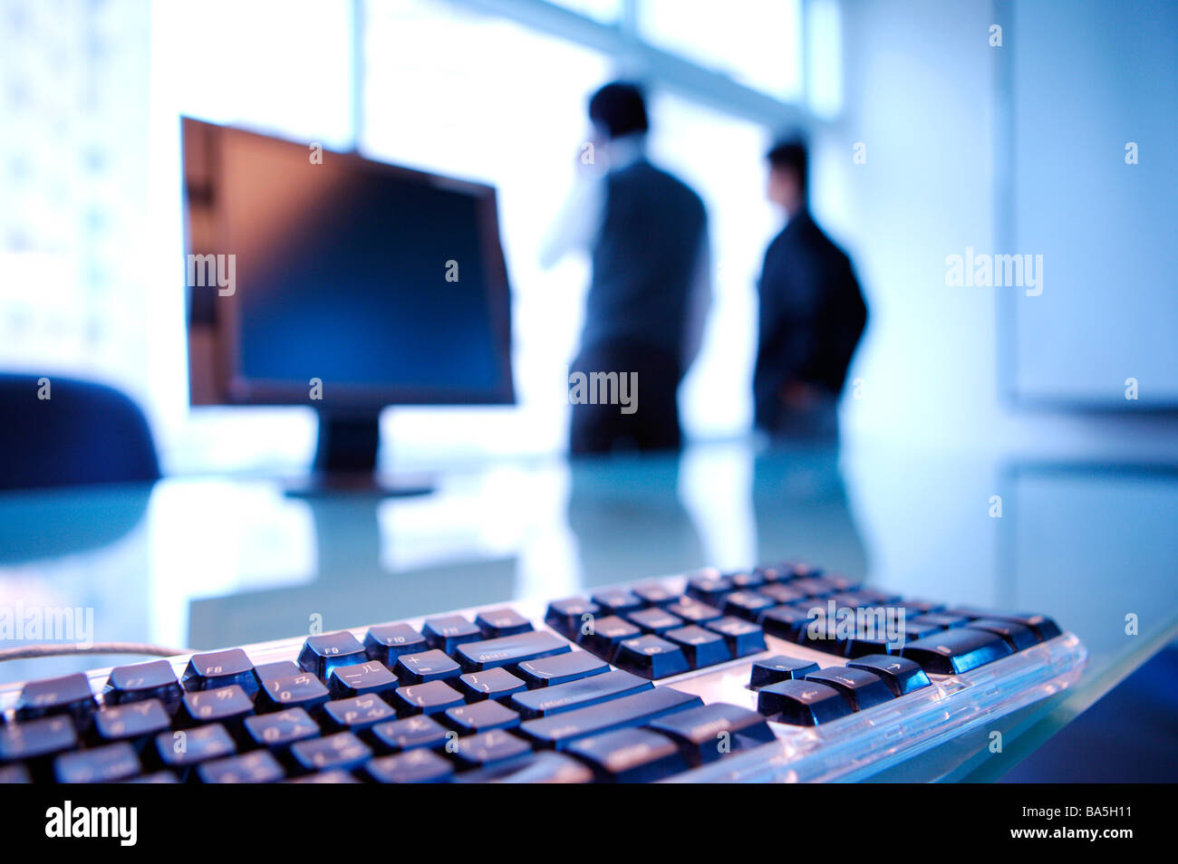 Geschäftsleuten stehen im Büro durch Fenster Tastatur auf dem Tisch in der front Stockfoto