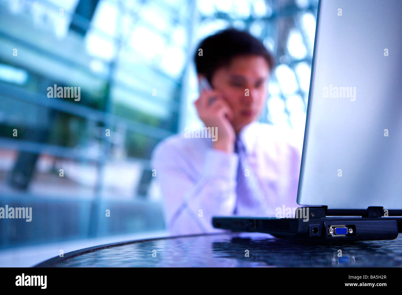 Geschäftsmann, sitzen von einem Laptop mit Handy Stockfoto