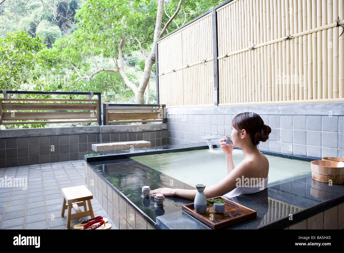 Junge Frau in Badetuch einweichen im Pool trinken Willen Rückansicht Stockfoto