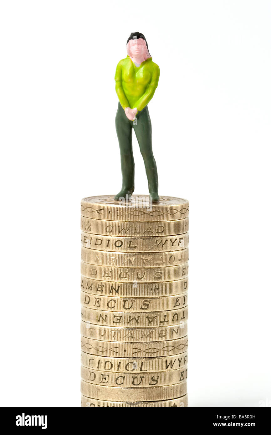 Modell der Frau auf Haufen von einem Pfund-Münzen Stockfoto