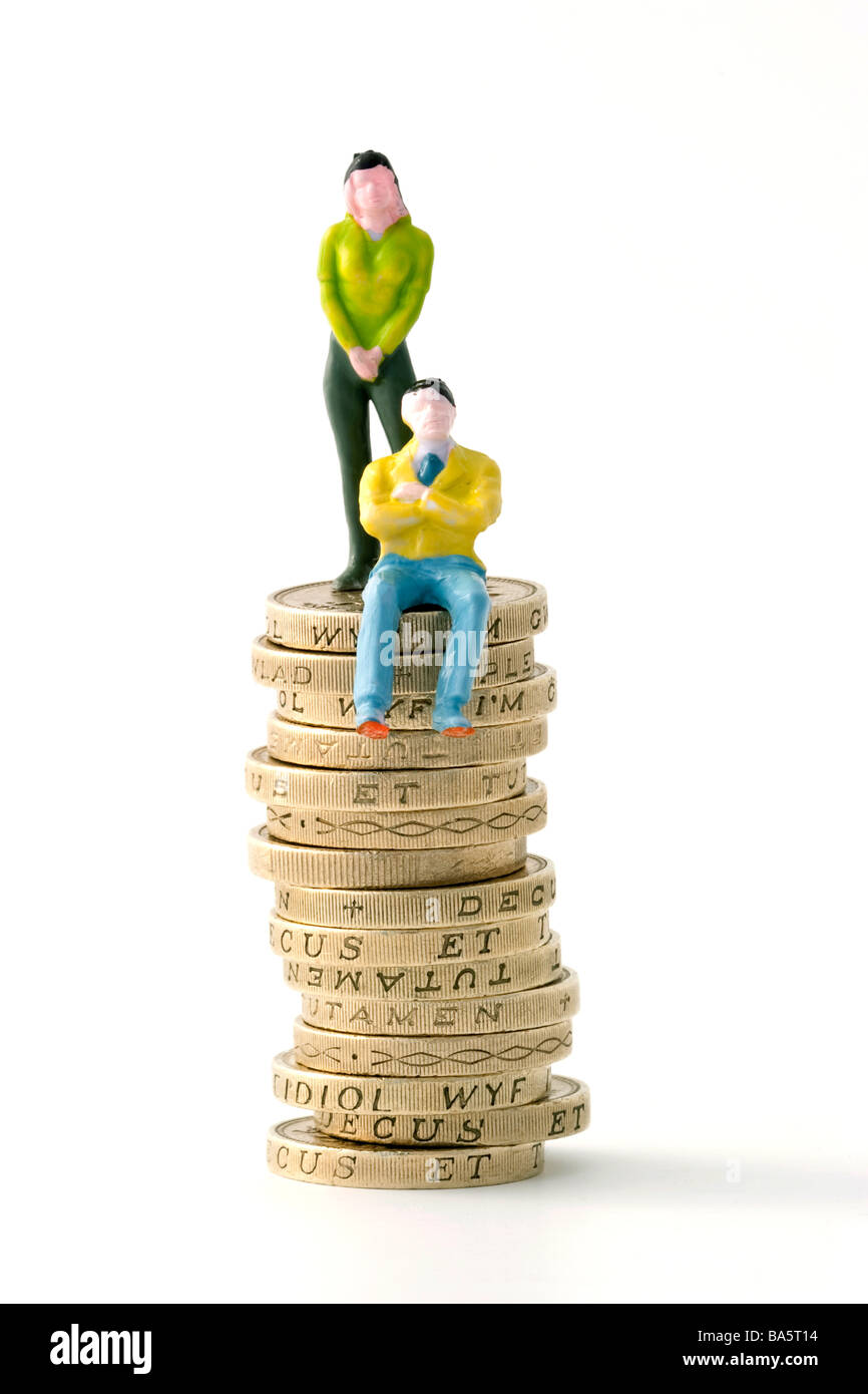 Modell von Mann und Frau auf Haufen von einem Pfund-Münzen Stockfoto