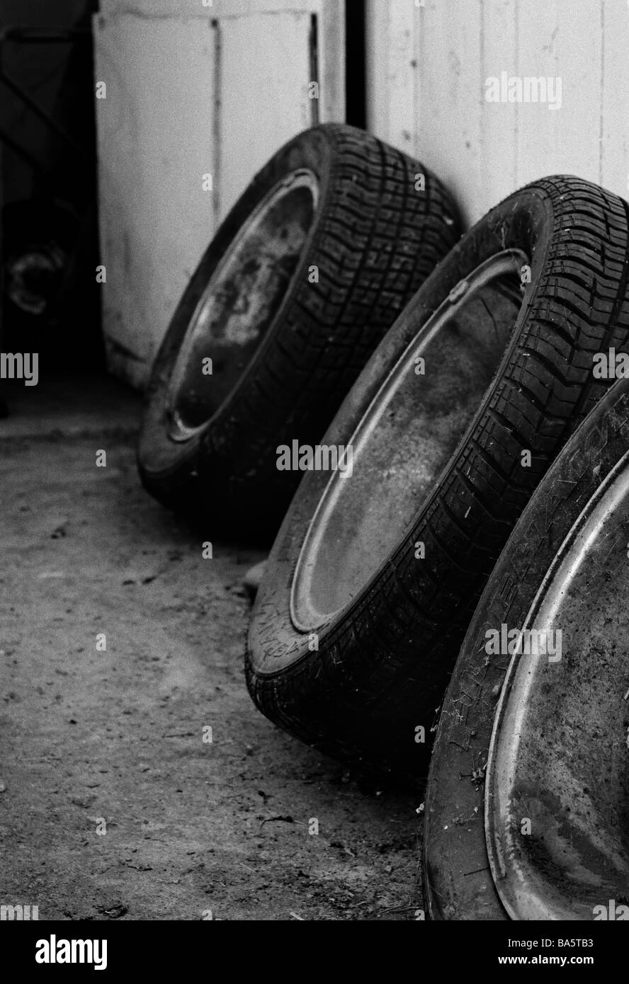 Eine Reihe von alten Reifen sitzen gegen eine Wand. Stockfoto