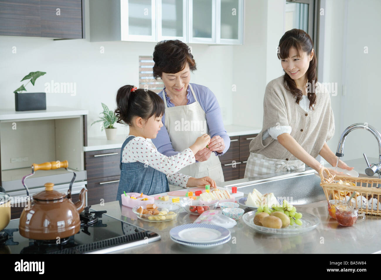 Asiatische Familie Peparing Frühstück in der Küche Stockfoto