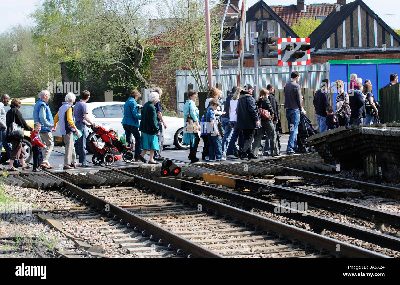 Fußgänger überqueren eine unbemannte Bahnübergang am Bahnhof von Petersfield Hampshire England UK Stockfoto