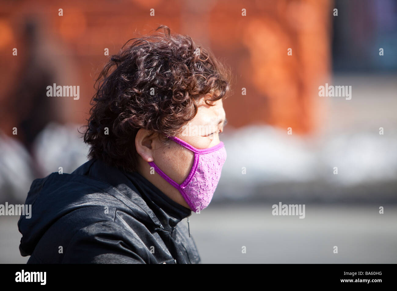 Eine Frau trägt eine Gesichtsmaske gegen die schrecklichen Luftverschmutzung in Suihua Stadt in Nordchina Stockfoto