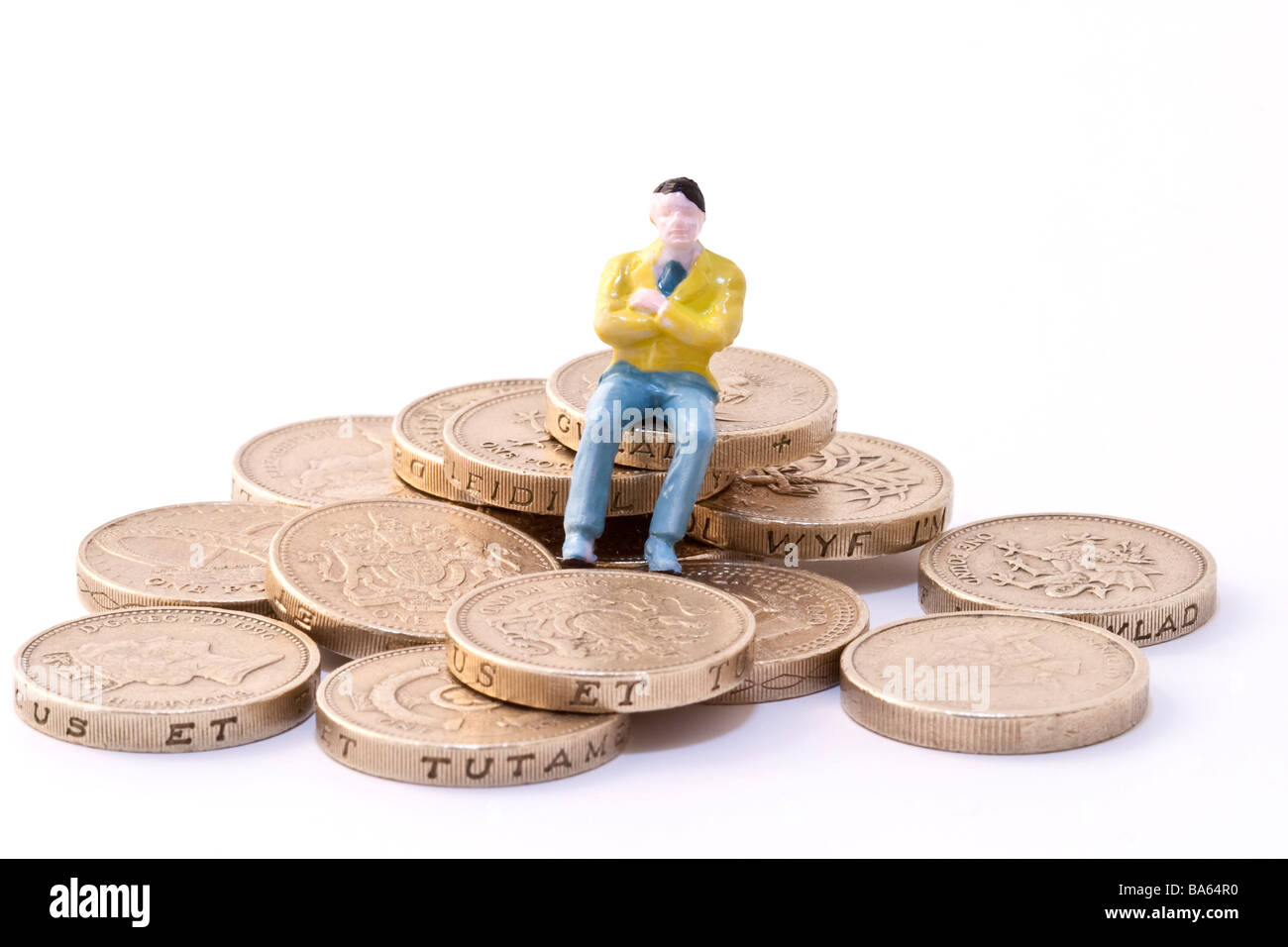 Modell der Mann sitzt auf Pfund-Münzen Stockfoto