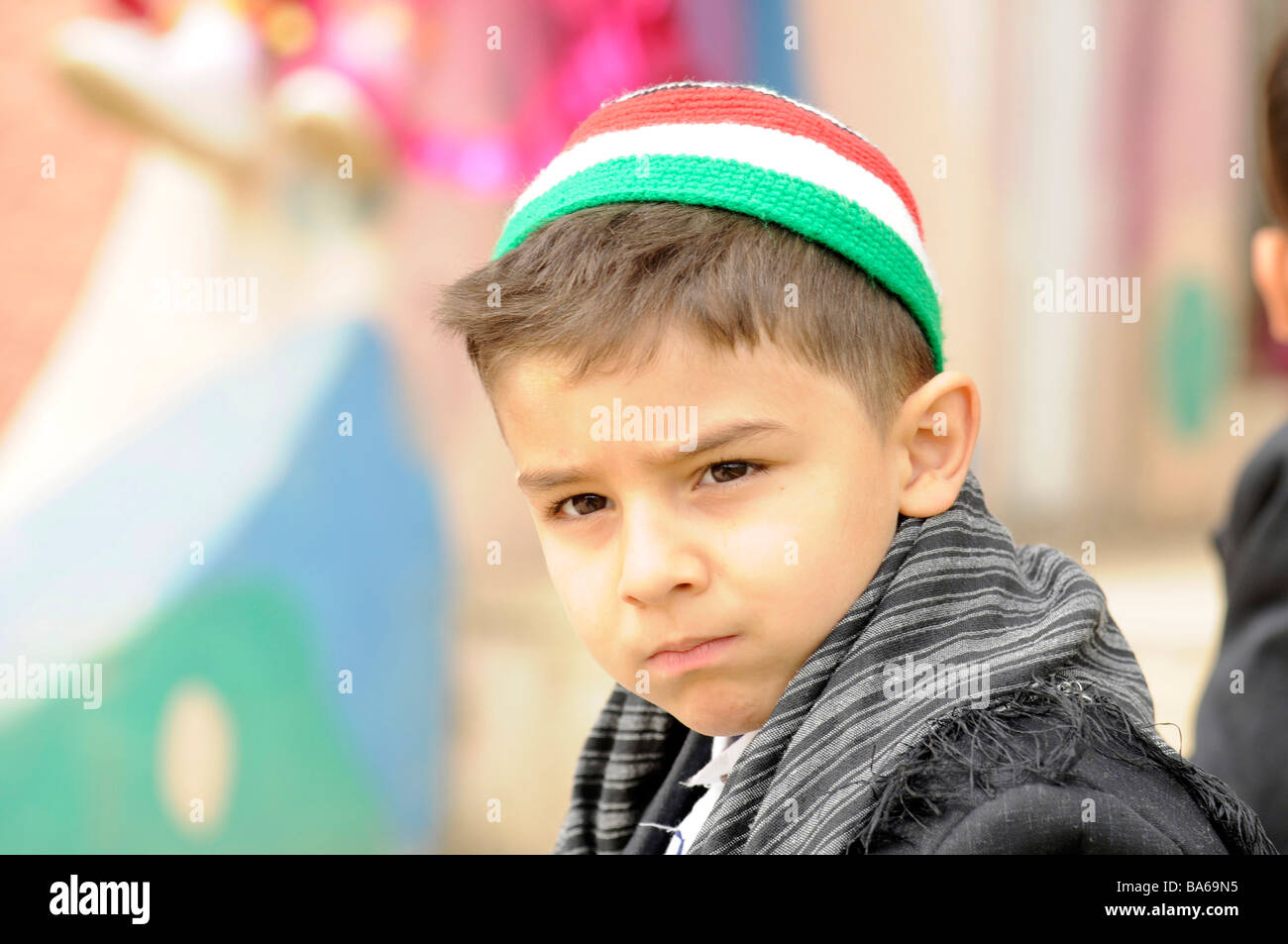 Porträt eines kurdischen Kindes mit einem Hut mit den Farben der Nationalflagge Kurdistan. Foto in Irakisch-Kurdistan. Stockfoto