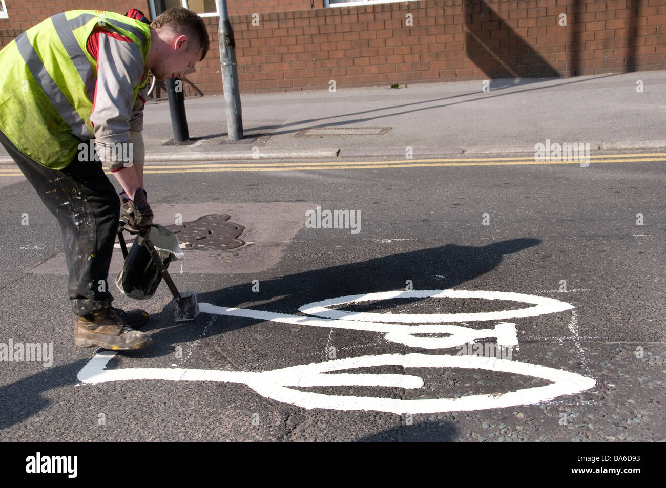 Des Rates Arbeiter Malerei weißen Fahrrad Symbole auf Straße, Radweg zu bezeichnen Stockfoto