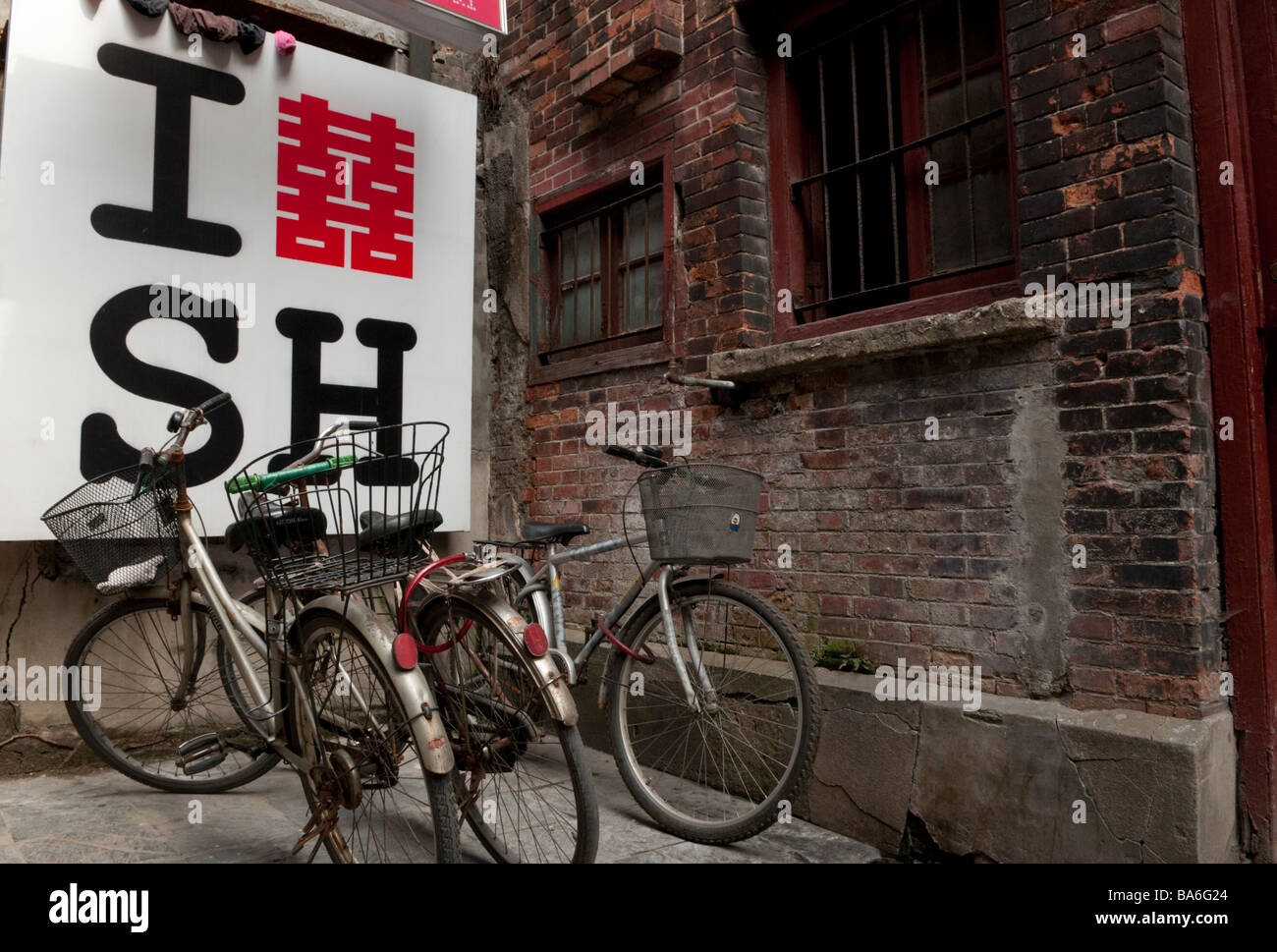 Fahrräder geparkt vor einem ich liebe Shanghai Zeichen in einer Gasse in Shanghai China Stockfoto
