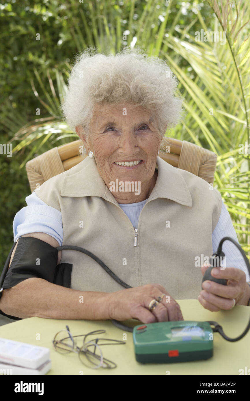 Blutdruck 130 Zu 70 Frau Terrasse senior Blutdruckmessung lächelt semi-Portrait-Serie Menschen