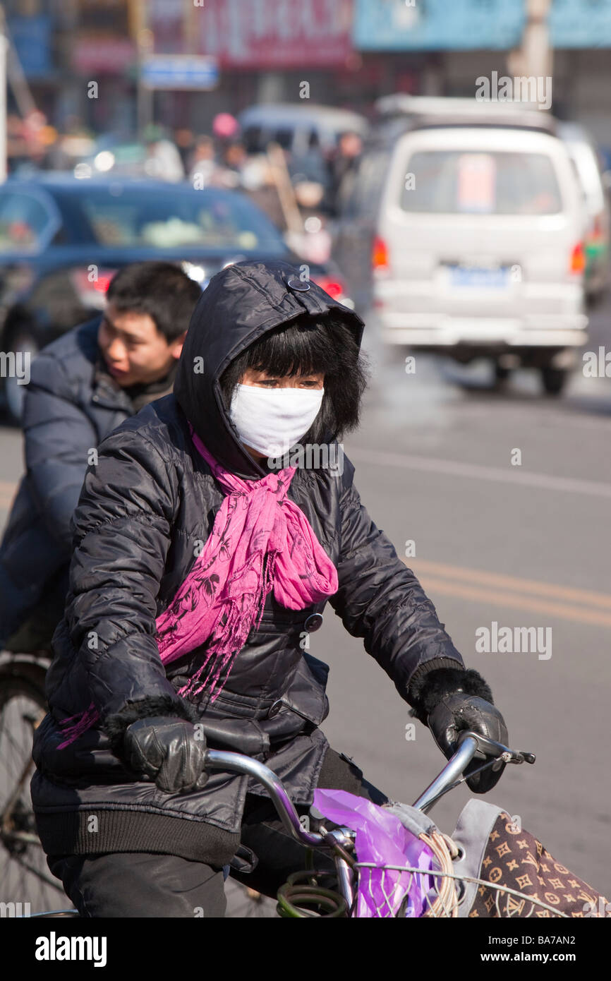 Eine Frau trägt eine Gesichtsmaske gegen die schrecklichen Luftverschmutzung in Suihua Stadt in Nordchina Stockfoto