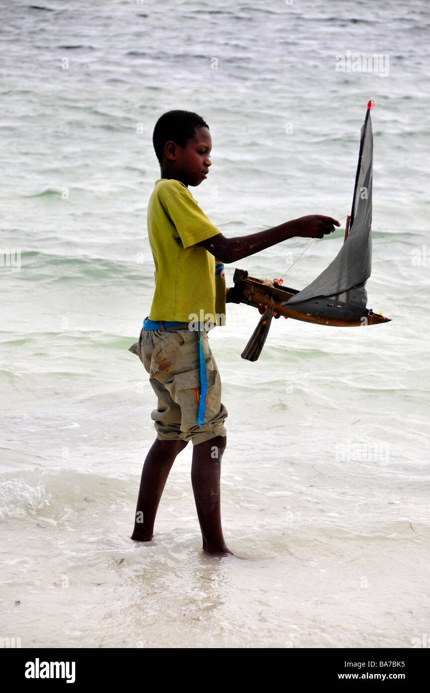 Jungen spielen mit Spielzeug Dhow Boot, Sansibar, Tansania Stockfoto