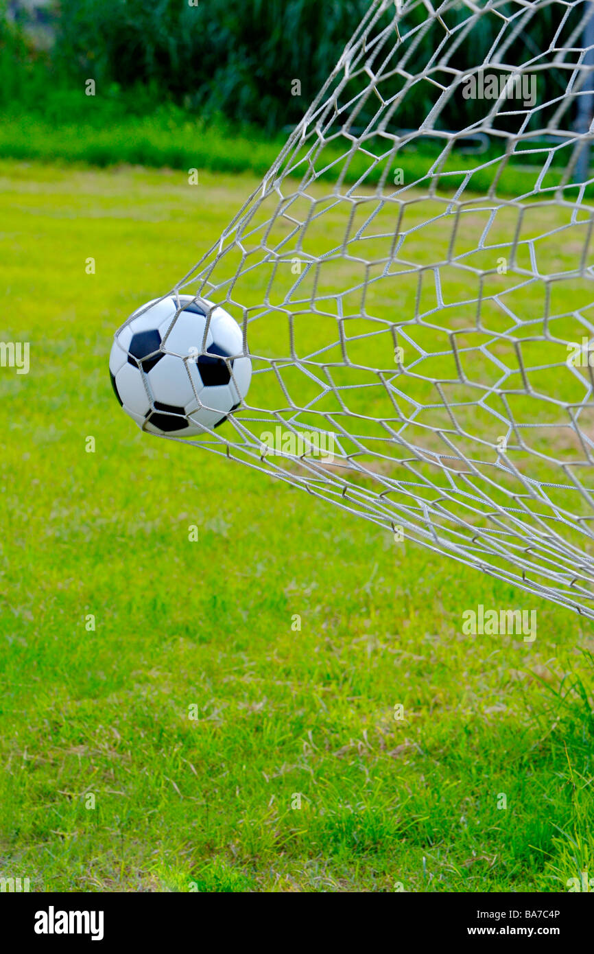 Schließen Sie bis zu einem Fußball, gefangen in einem Ziel netto auf dem Fußballplatz Stockfoto