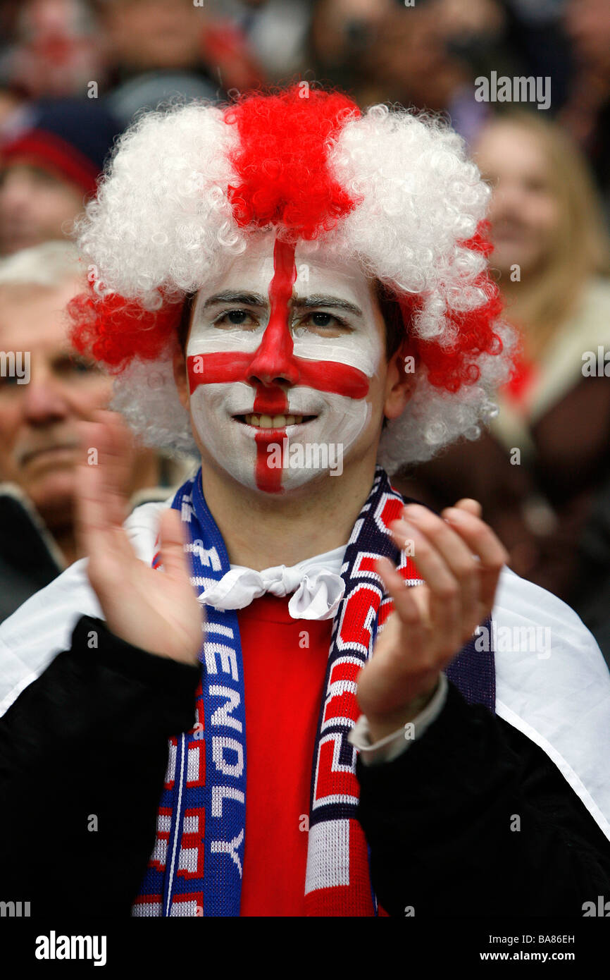 Ein England-Fußball-Fan mit einem gemalten Gesicht und tragen eine bunte Perücke auf den Rängen vor einem Spiel Stockfoto