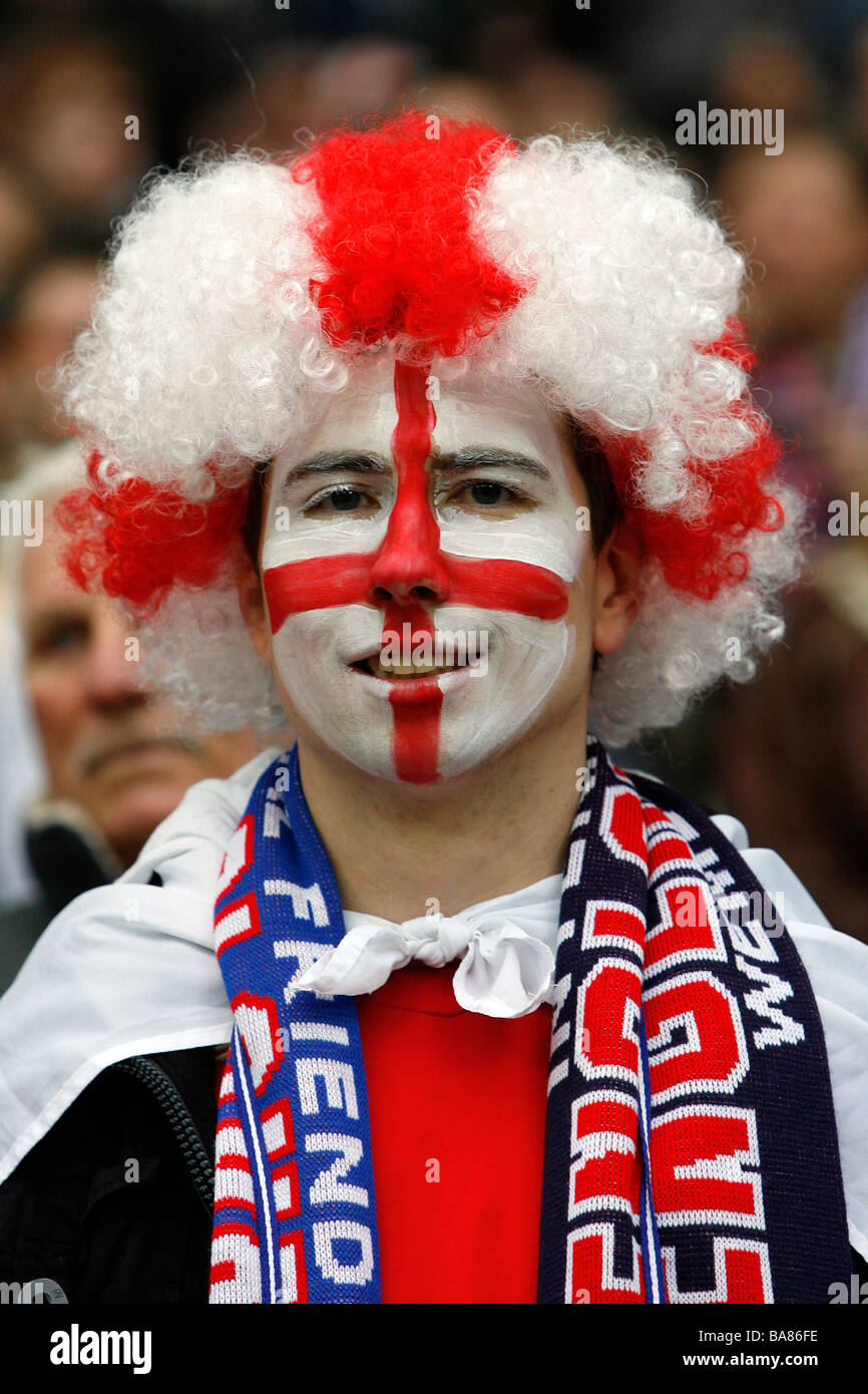 Ein England-Fußball-Fan mit einem gemalten Gesicht und tragen eine bunte Perücke auf den Rängen vor einem Spiel Stockfoto