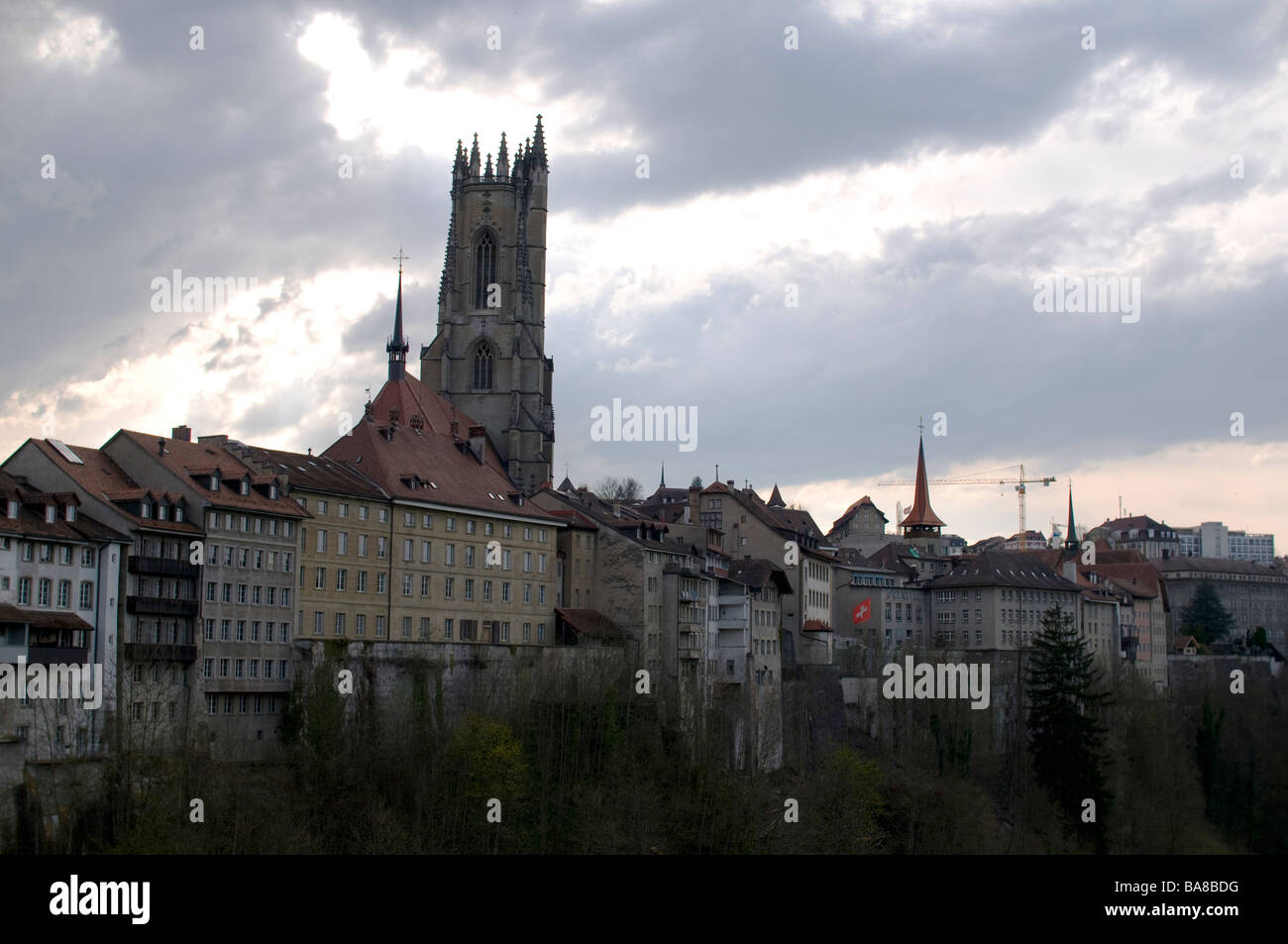 Typische Gebäude, unterstützt durch die gotische Turm der Kathedrale des Heiligen Nikolaus, Fribourg, Schweiz Stockfoto