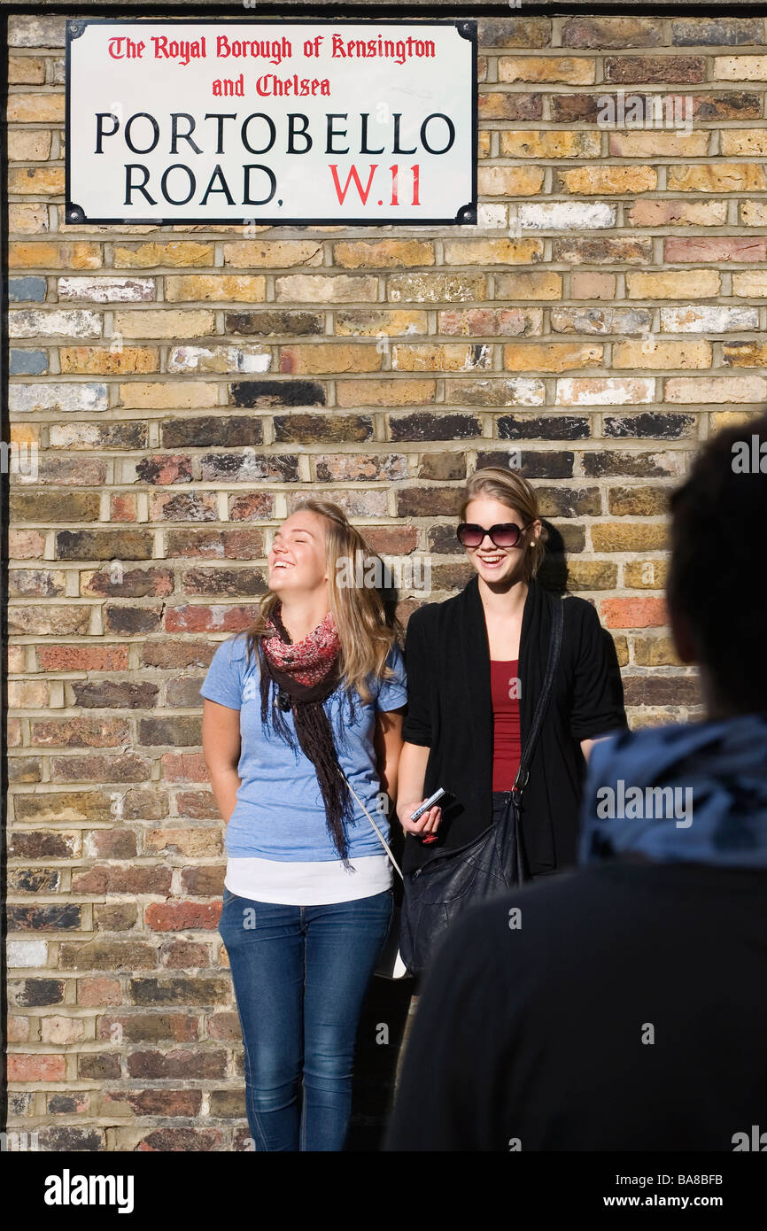 London, UK. Touristen posieren für Fotos unter Portobello Road unterschreiben auf dem Markt Stockfoto