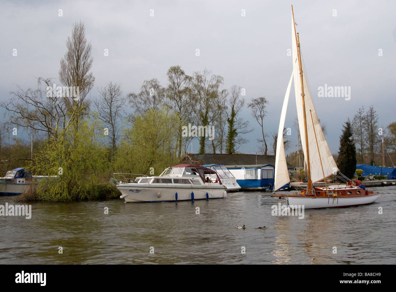 Der Fluss Bure Horning zu erreichen, auf der Norfolk Broads, England mit Motorboot und Segelyacht an einem Frühlingstag. Stockfoto