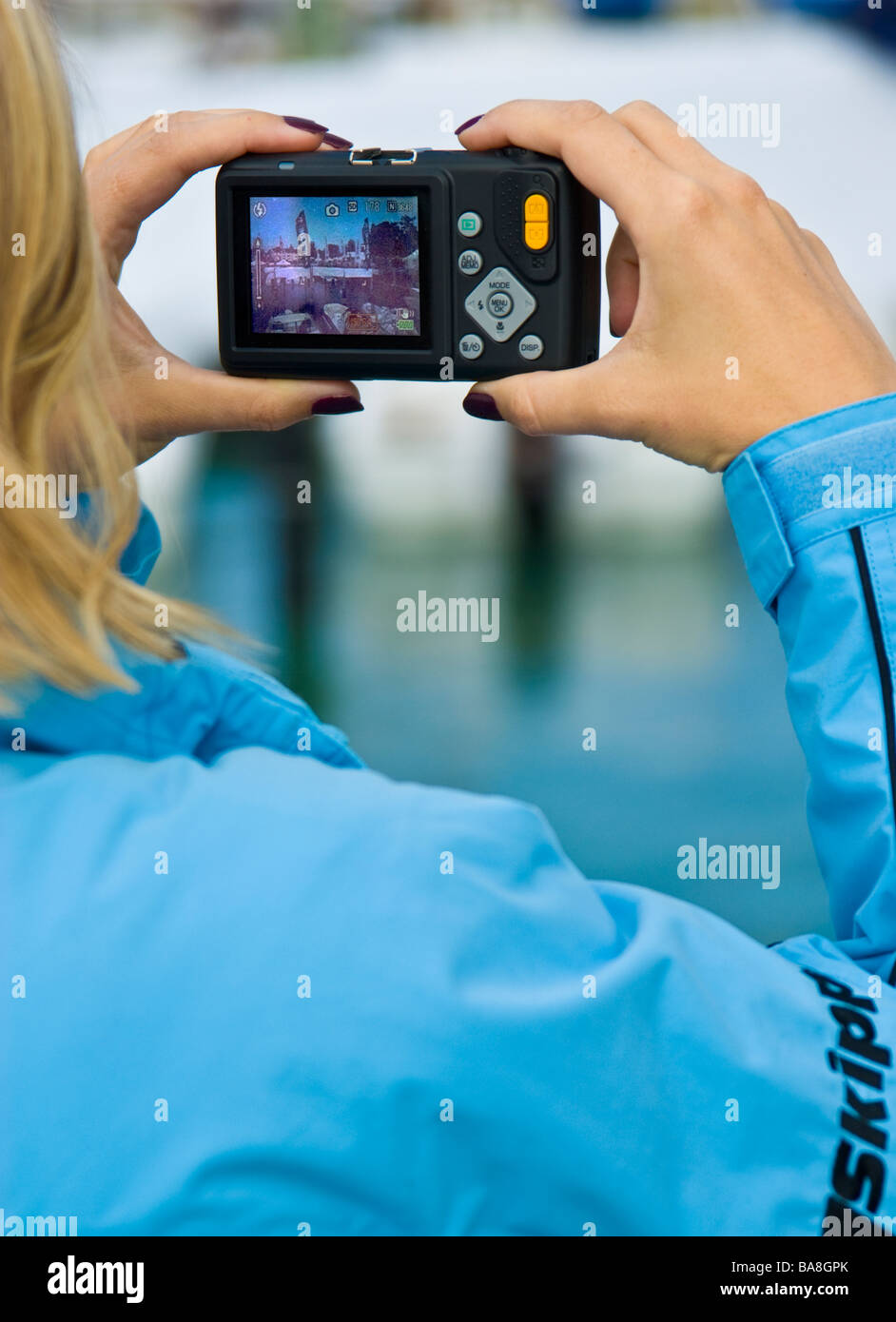 Blondes Mädchen mit kompakten Digitalkamera unter Bild Blondes Mädchen bei Mit Digitaler Kompaktkamera Stockfoto