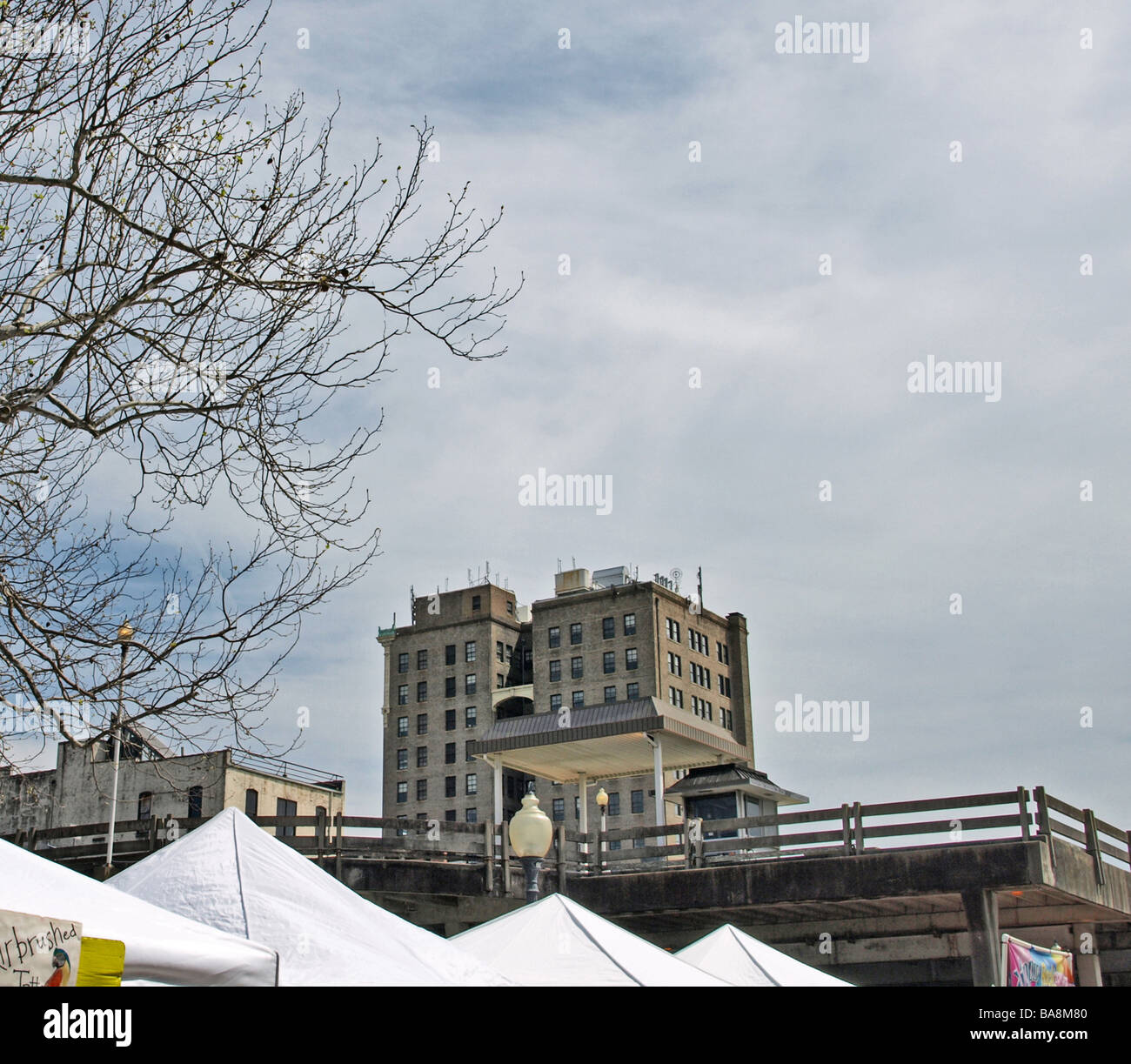 Parkplatz Garage und gewerblich genutzten Gebäuden mit grauen Himmel und weißen Zelt Tops im Vordergrund, Festivaltag Stockfoto