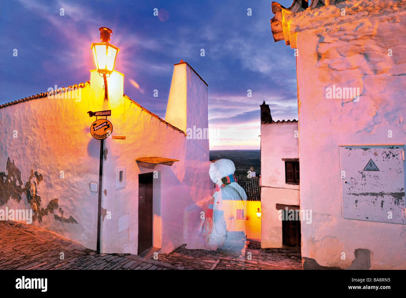 Tourist, vorbei an der Santiago-Gasse in Monsaraz im Winter Stockfoto