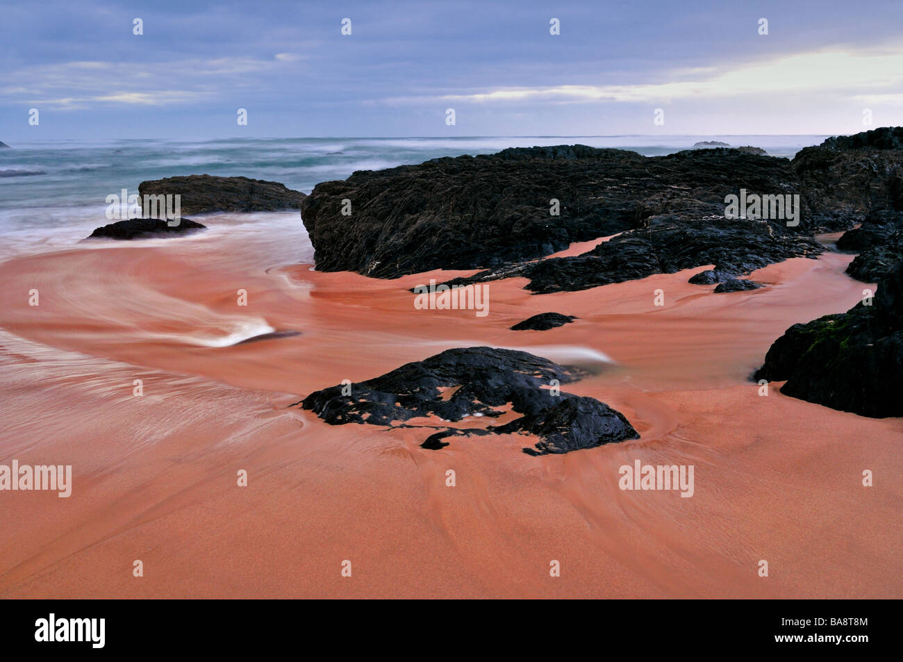 Felsen und Wellen am Strand von Almograve Stockfoto