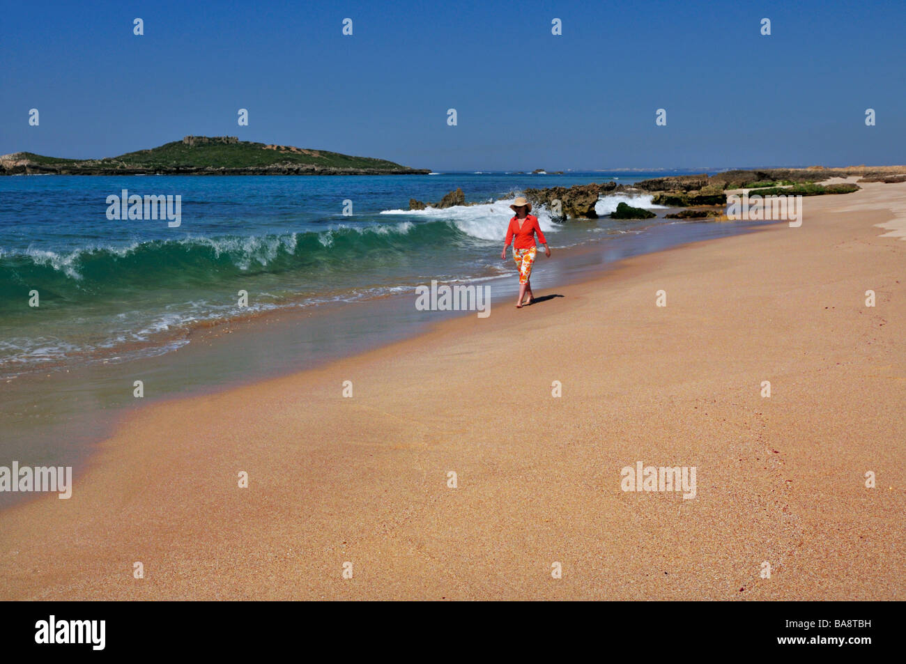 Frau mit Hut zu Fuß am Strand Ilha de Pessegueiro Stockfoto