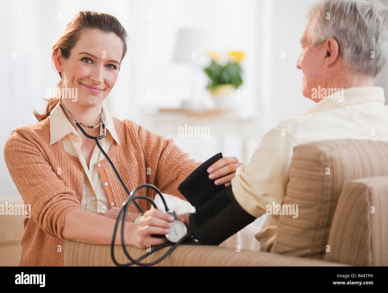 Krankenschwester, die senior woman Blutdruckmessung Stockfoto