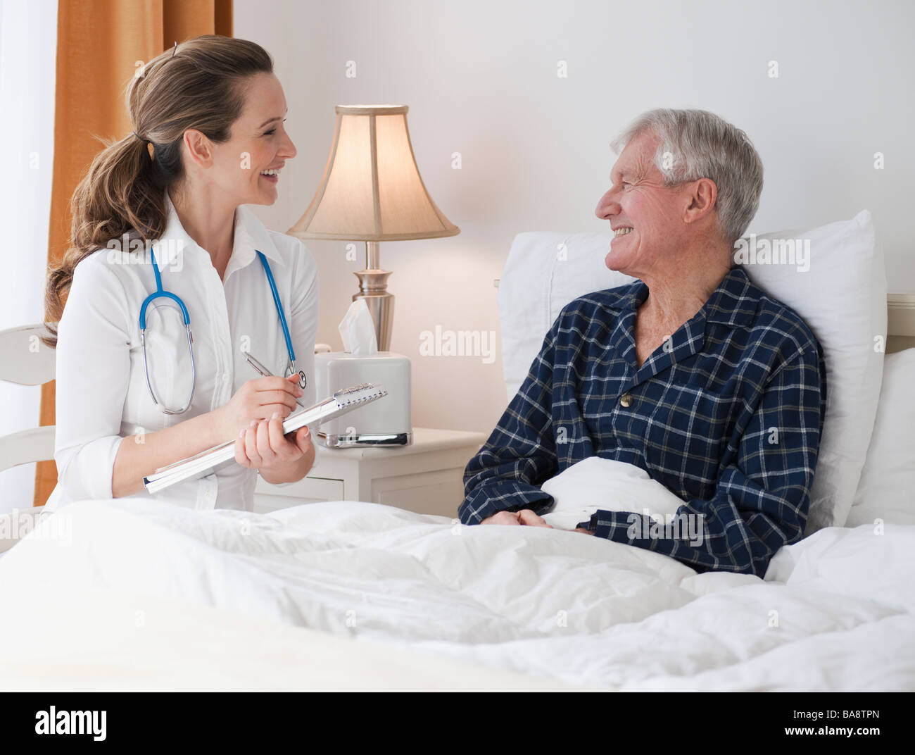 Krankenschwester, Betreuung von älteren Mann im Bett Stockfoto
