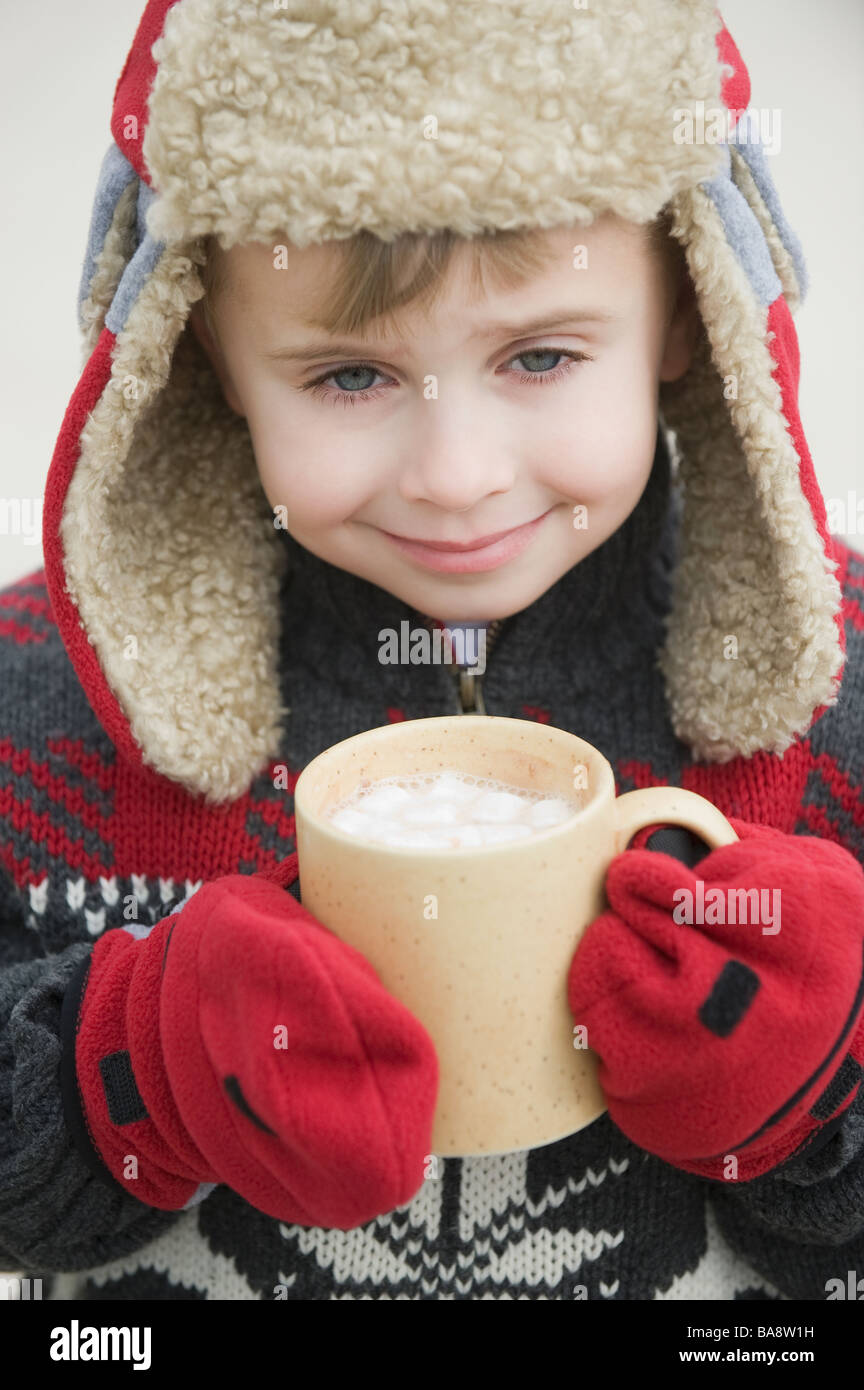 Junge in warme Mütze trinken heißen Schokolade Stockfoto