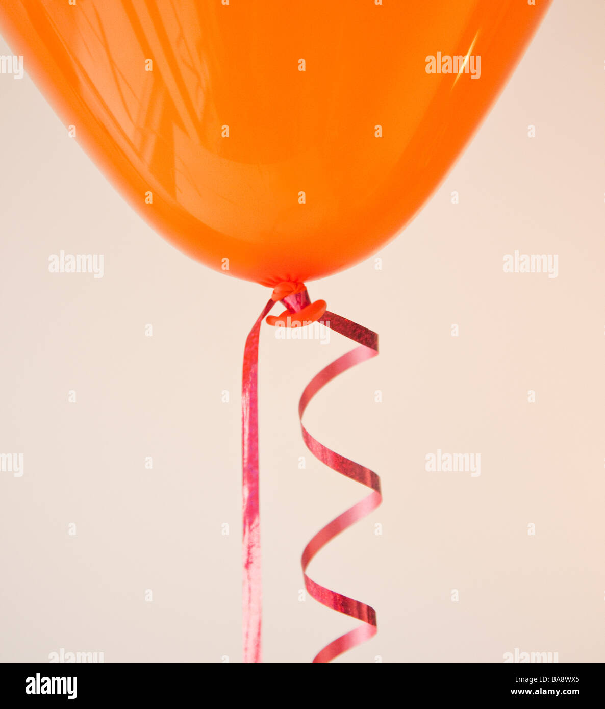 Orangefarbenen Ballon und Band Stockfoto