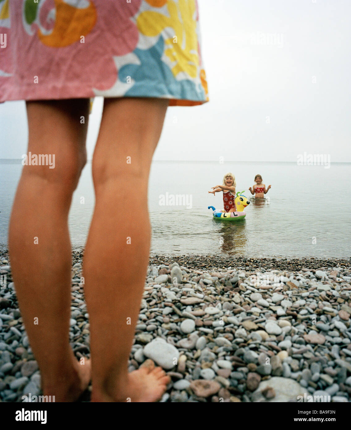 Mutter, beobachten Sie ihre Kinder im Wasser, Ooland, Schweden. Stockfoto