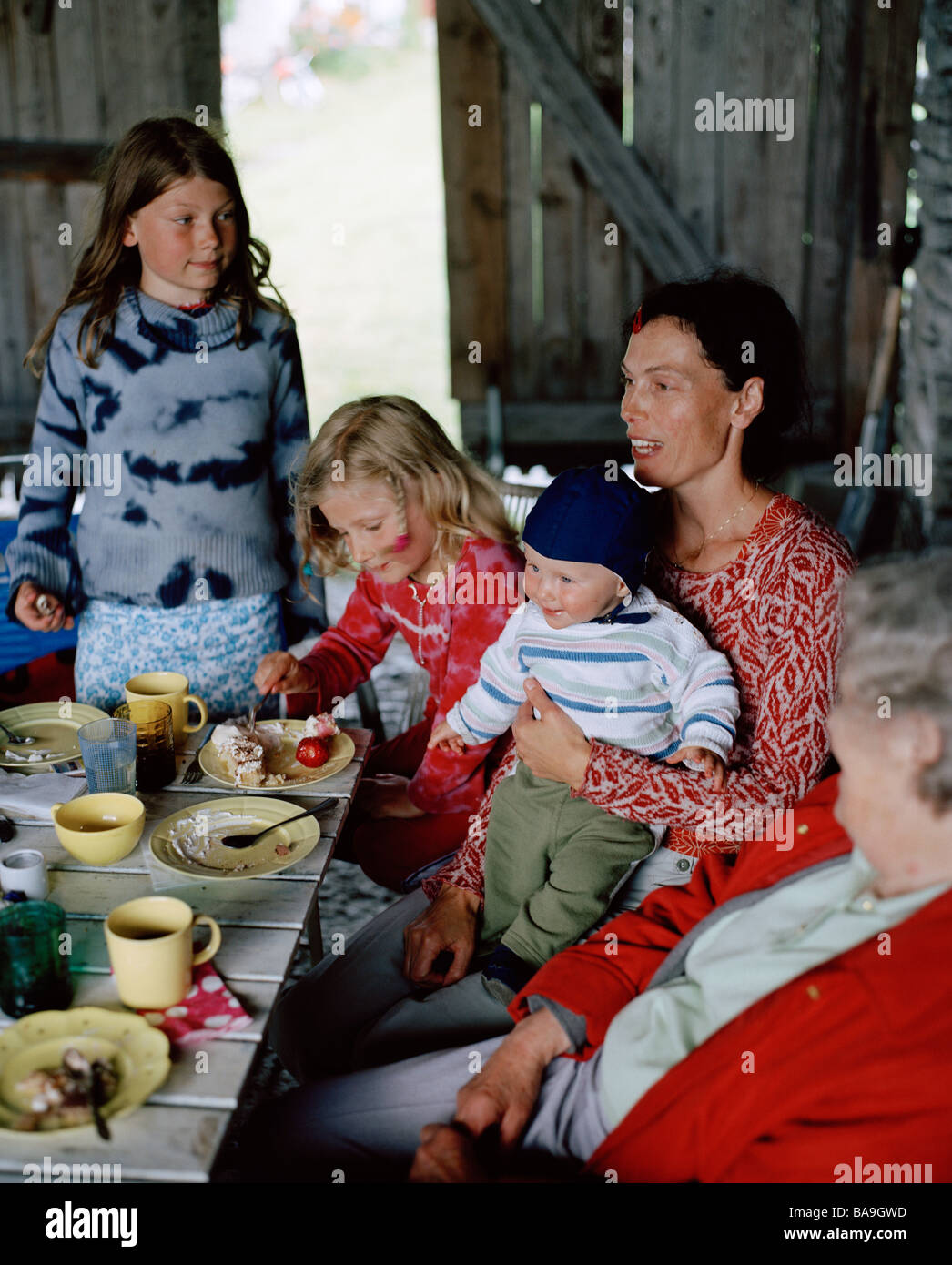 Zwei Frauen und drei Kinder mit einem Kuchen, Öland, Schweden. Stockfoto