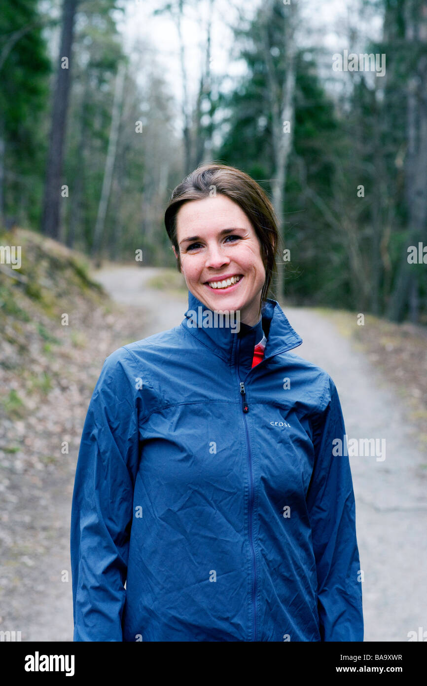 Porträt einer lächelnden Frau in einem Wald, Schweden. Stockfoto
