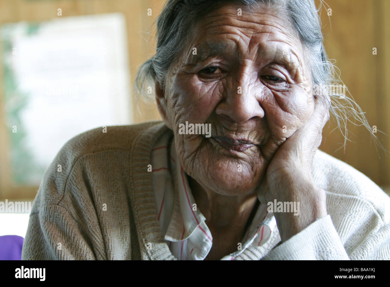 First Nations ältere Frau sitzt alleine in ihrer Küche in der Gemeinde von Old Crow, Yukon Territorium, Kanada. Stockfoto