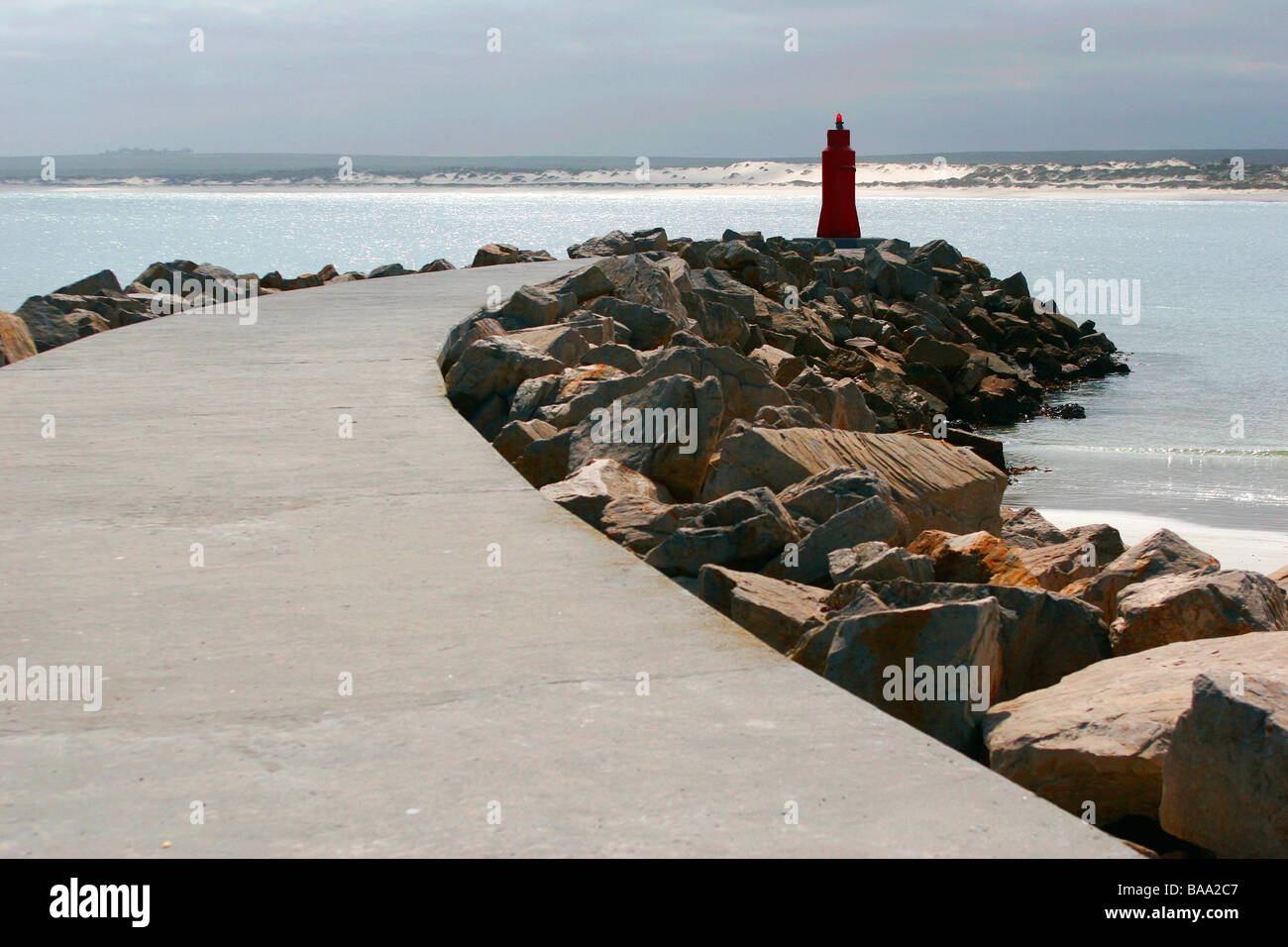 Ein Gehweg, der wirkt wie ein Wellenbrecher zu einem Leuchtturm in der küstennahen Dorf Lambertsbay in Südafrikas Westküste führt Stockfoto