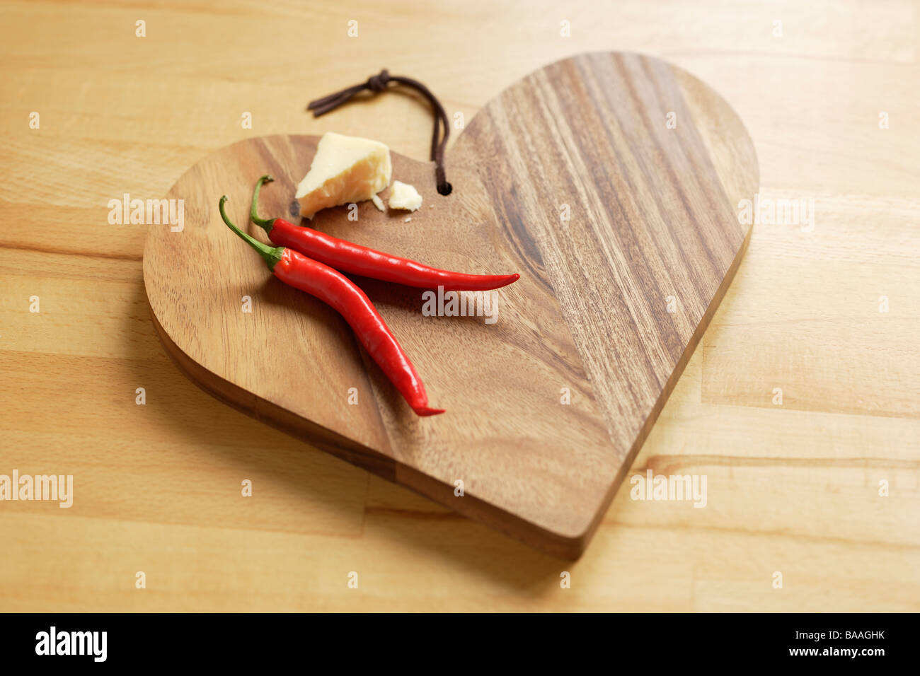 Käse und Chili auf ein Herz geformt Holzbrett Stockfoto