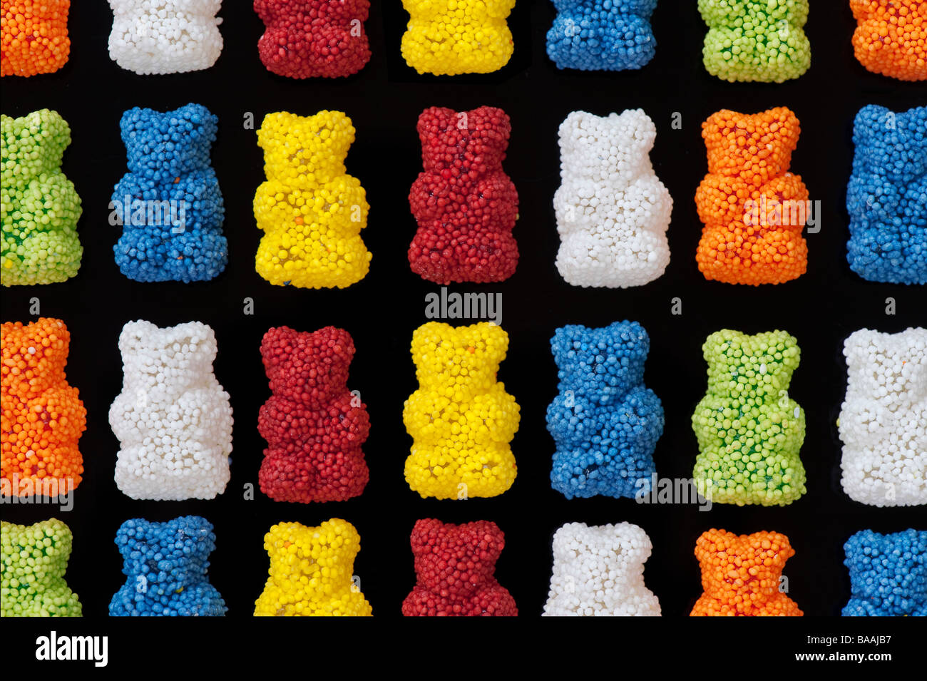 Bunte Gummibärchen Süßigkeiten Muster auf Schwarz Stockfoto