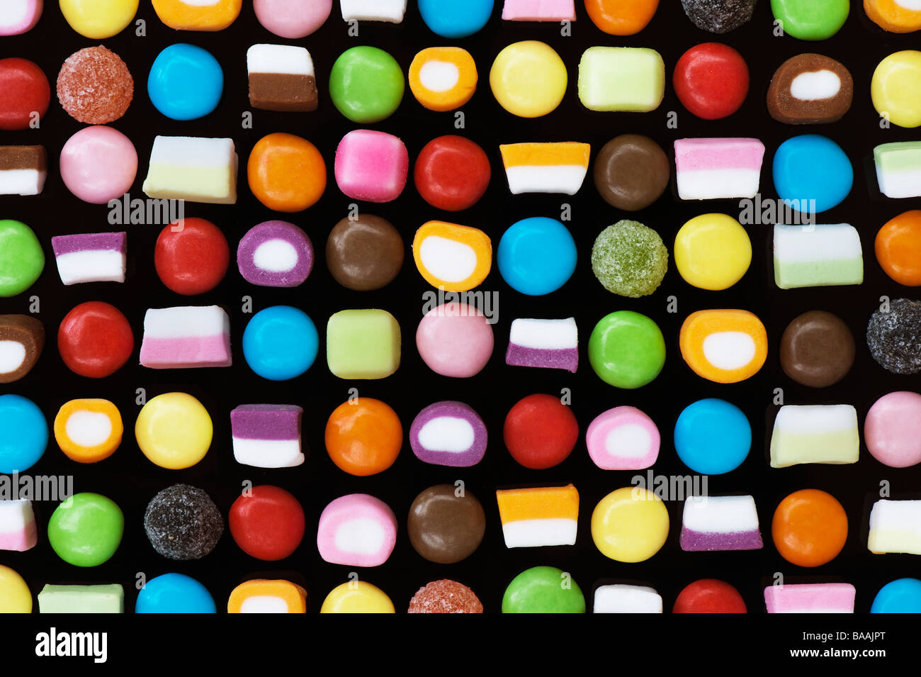 Mehrfarbige dolly Mischungen und smarties Süßigkeiten Muster auf Schwarz Stockfoto