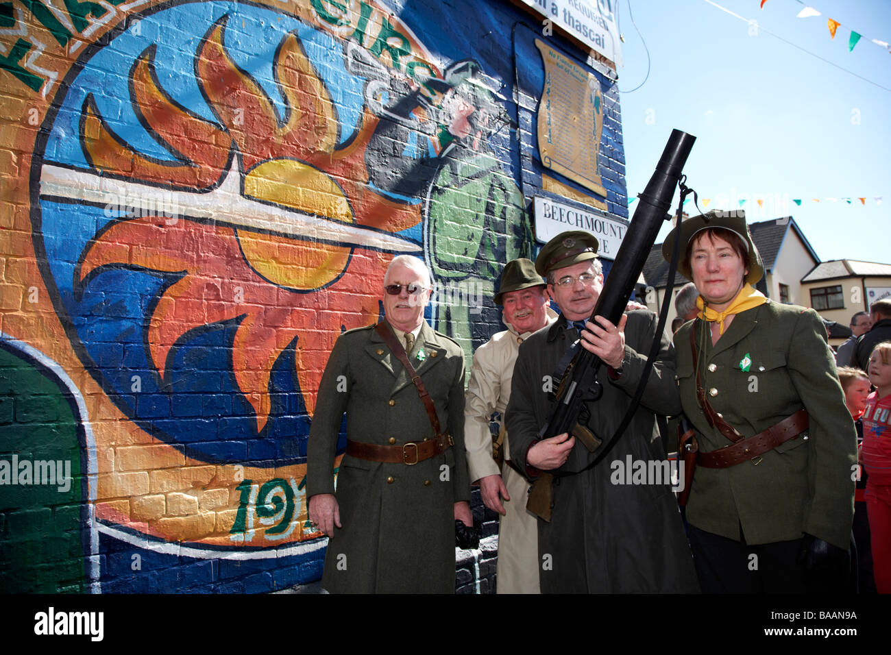 Reinactors gekleidet wie eine alte IRA fliegen Spalte Stand vor der Fianna Eireann Wandbild am Ostersonntag auf den Osteraufstand Stockfoto