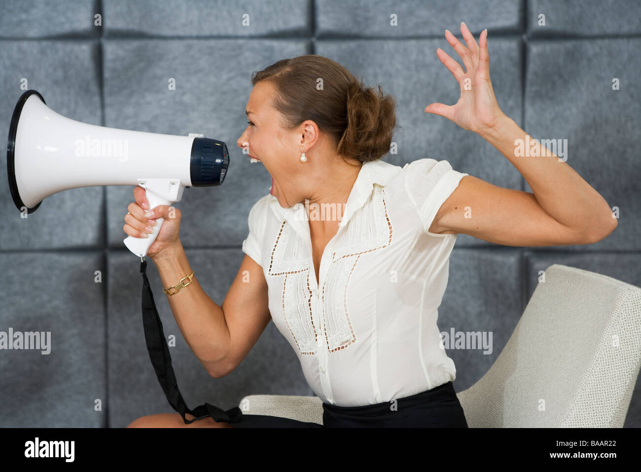 Eine Frau schrie in ein Megaphon in einem Büro, Schweden. Stockfoto