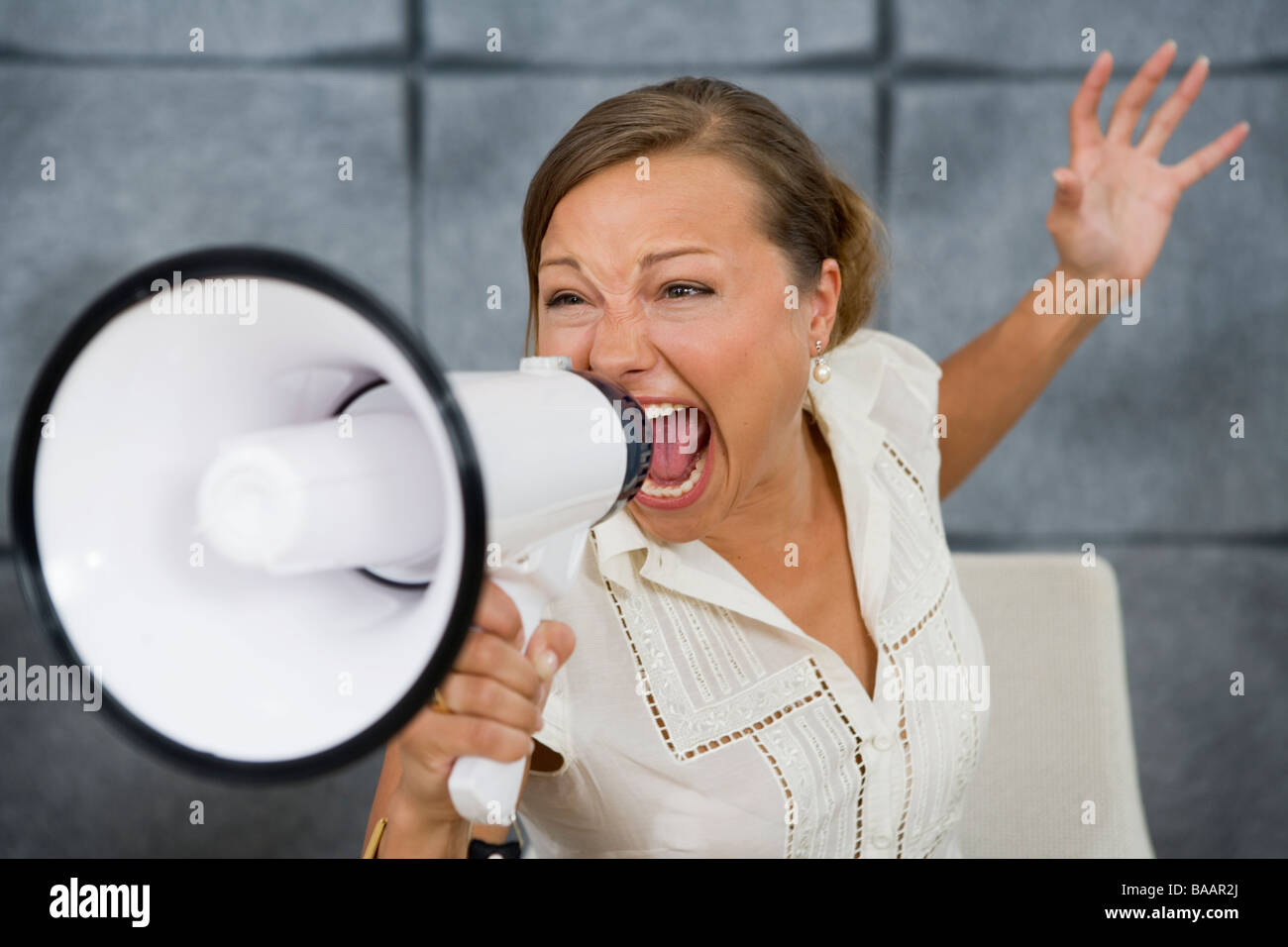 Eine Frau schrie in ein Megaphon in einem Büro, Schweden. Stockfoto