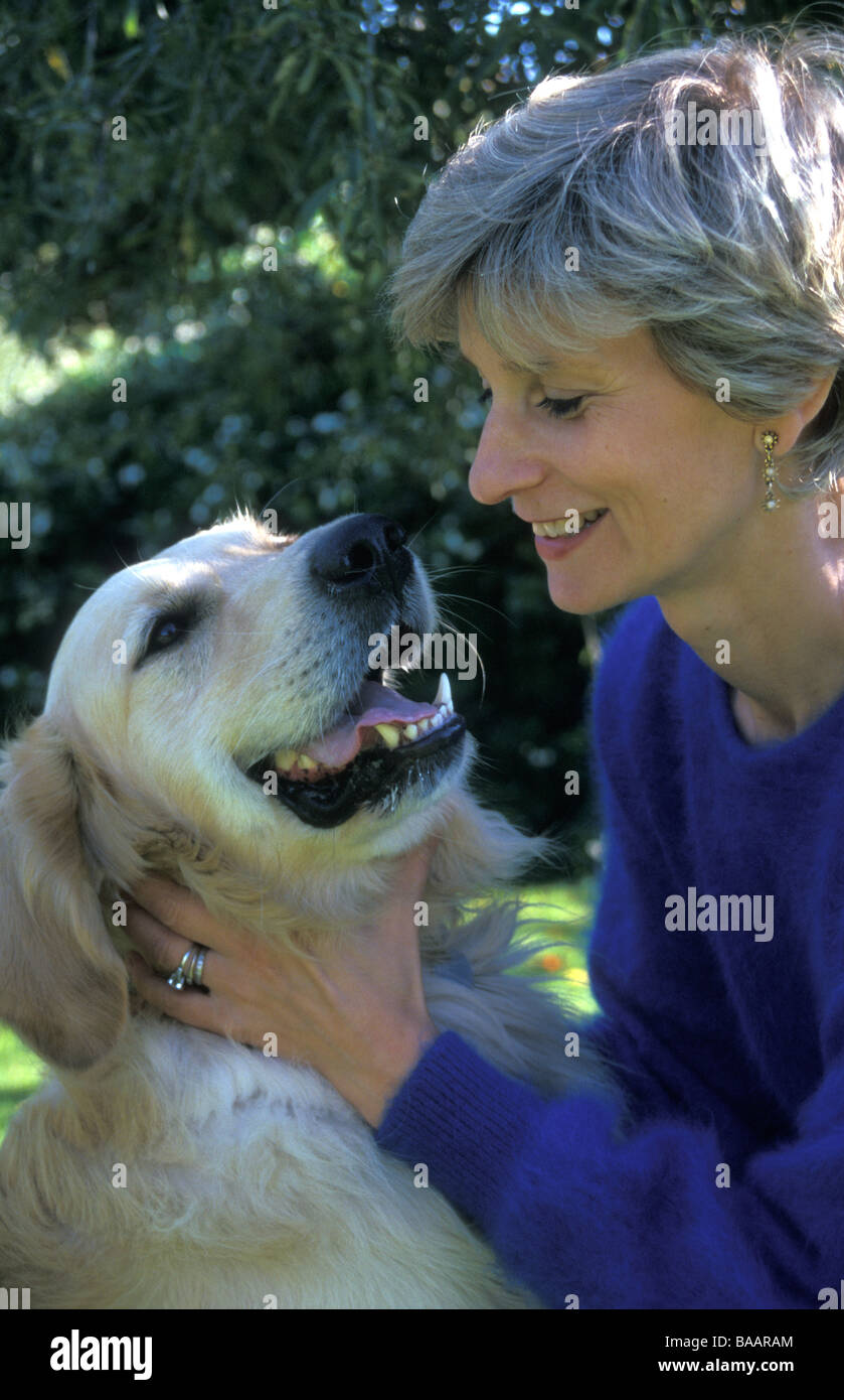 Lady macht viel Aufhebens von ihren Erwachsenen golden Retriever Hund Stockfoto