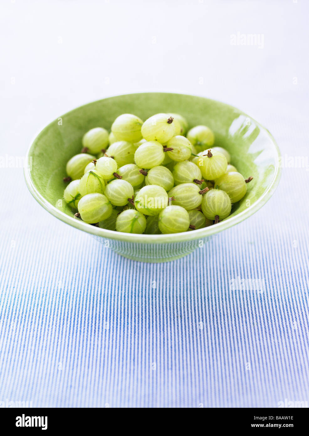 Stachelbeeren in eine Schüssel geben. Stockfoto