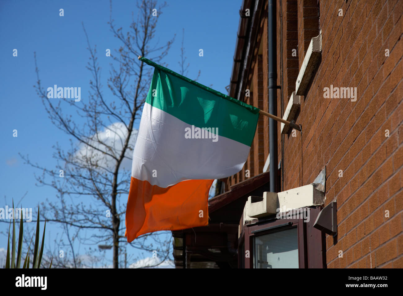 Irische Trikolore grün weiß und orange Flagge aus einem Haus in einem republikanischen Belfast Nordirland Stockfoto